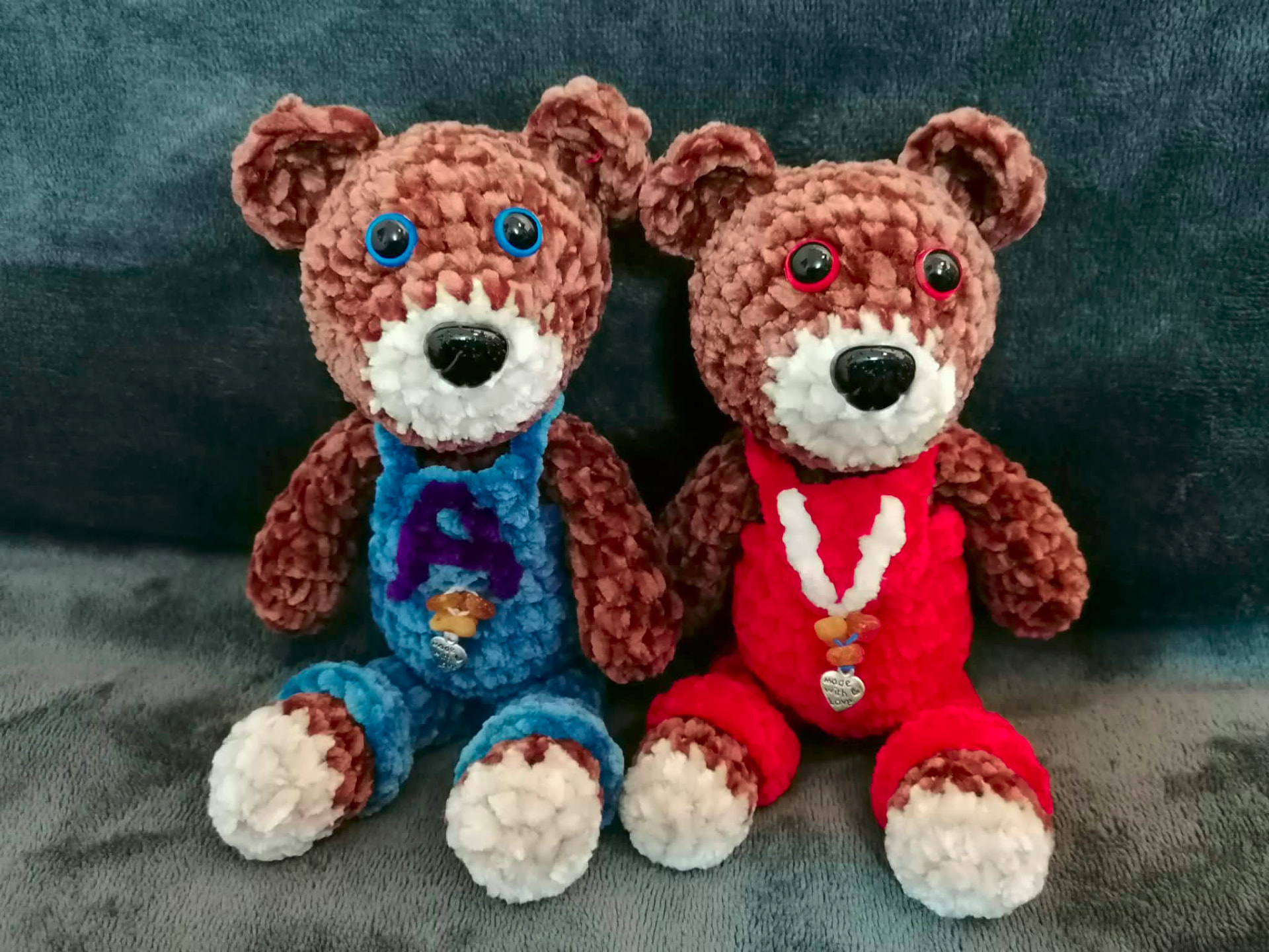 Two handmade teddy bears in blue and red outfits, showing colour variations