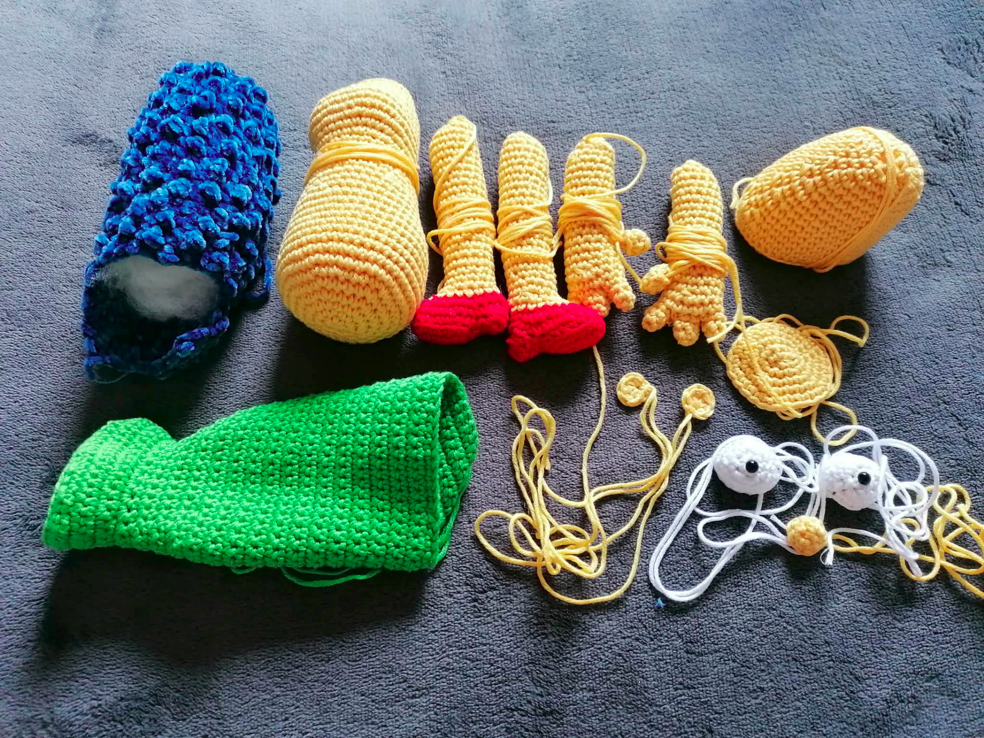 Separate handmade crocheted pieces laid out before assembly
